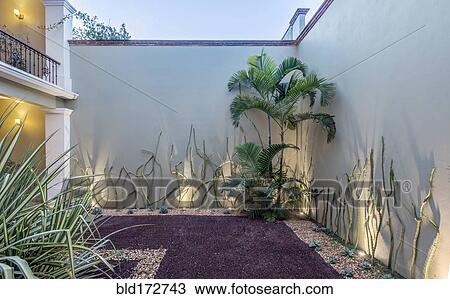 Stock Image - Landscaping along gravel path at hotel. Fotosearch
