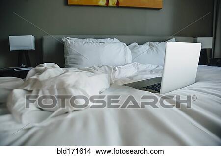 Picture - Laptop on empty bed. Fotosearch