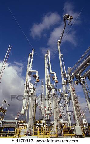 Stock Photo - Low angle view of shipping cranes in industrial shipyard. Fotosearch