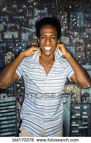 Man lifting his collar by mural View Large Photo Image Stock Photo - Man lifting his collar by mural. Fotosearch