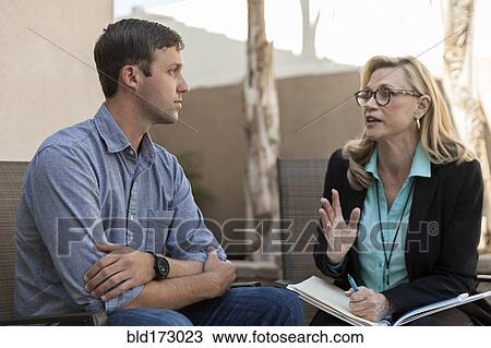 Stock Image - Man talking with therapist in therapy. Fotosearch