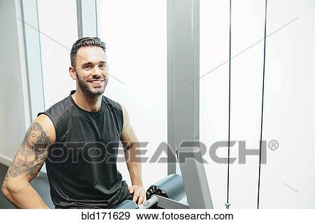 Man using exercise machine in gymnasium View Large Photo Image Stock Photo - Man using exercise machine in gymnasium. Fotosearch