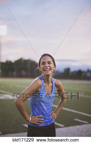 Stock Photo - Mixed race athlete laughing on sports field. Fotosearch