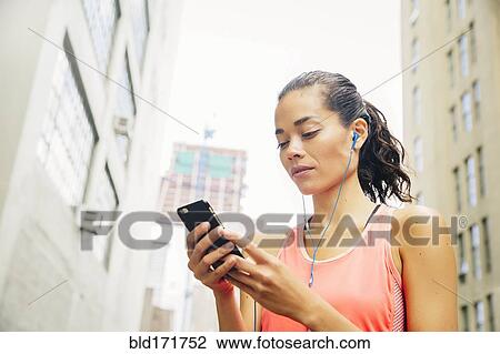 Mixed race athlete listening to mp3 player in city View Large Photo Image Stock Image - Mixed race athlete listening to mp3 player in city. Fotosearch