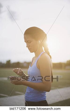 Mixed race athlete listening to mp3 player on sports field View Large Photo Image Stock Photograph - Mixed race athlete listening to mp3 player on sports field. Fotosearch