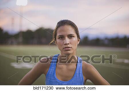 Stock Image - Mixed race athlete standing on sports field. Fotosearch