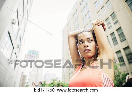Mixed race athlete stretching in city View Large Photo Image Stock Image - Mixed race athlete stretching in city. Fotosearch