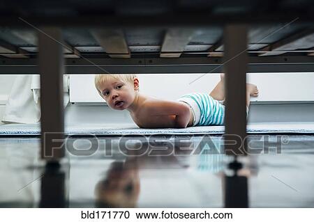 Mixed race boy peering under bed View Large Photo Image Stock Image - Mixed race boy peering under bed. Fotosearch
