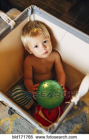 Mixed race boy playing in laundry hamper View Large Photo Image Stock Photography - Mixed race boy playing in laundry hamper. Fotosearch