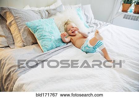Mixed race boy playing on bed View Large Photo Image Stock Photo - Mixed race boy playing on bed. Fotosearch