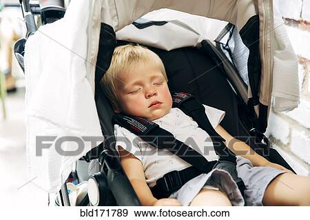 Stock Photo - Mixed race boy sleeping in stroller. Fotosearch