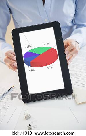 Stock Image - Mixed race businesswoman holding digital tablet with pie chart. Fotosearch