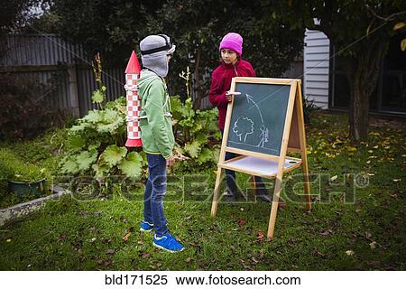 Stock Photography - Mixed race children planning jetpack rocket. Fotosearch