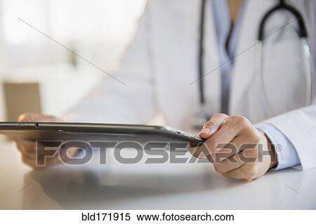 Mixed race doctor using digital tablet View Large Photo Image Stock Photography - Mixed race doctor using digital tablet. Fotosearch