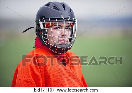 Stock Photo - Mixed race field hockey goalie wearing helmet. Fotosearch