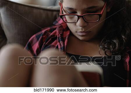 Mixed race girl reading on sofa View Large Photo Image Stock Image - Mixed race girl reading on sofa. Fotosearch