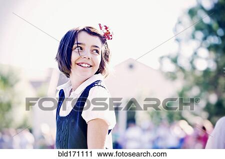 Stock Image - Mixed race girl smiling outdoors. Fotosearch