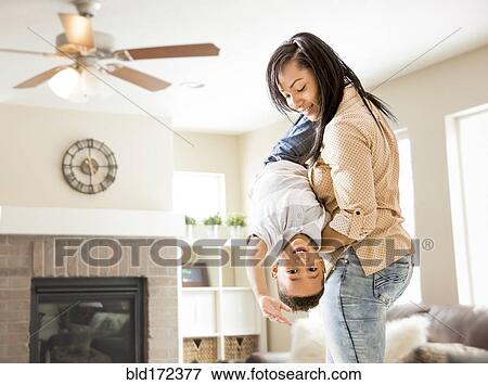 Stock Photo - Mixed race mother and son playing in living room. Fotosearch