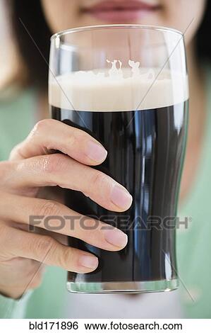 Mixed race woman drinking glass of dark beer View Large Photo Image Stock Photograph - Mixed race woman drinking glass of dark beer. Fotosearch
