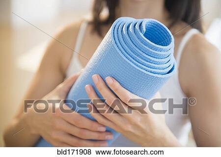 Mixed race woman holding exercise mat View Large Photo Image Stock Photo - Mixed race woman holding exercise mat. Fotosearch