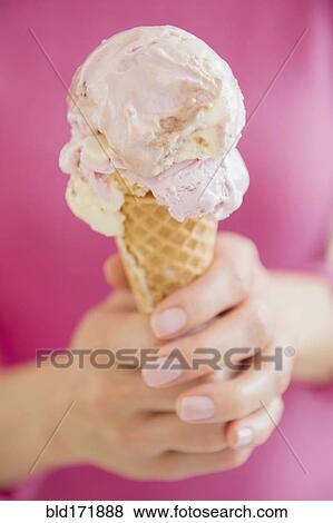Stock Photo - Mixed race woman holding ice cream cone. Fotosearch