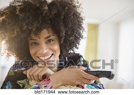 Mixed race woman holding television remote control View Large Photo Image Picture - Mixed race woman holding television remote control. Fotosearch