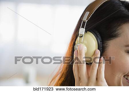 Mixed race woman listening to headphones View Large Photo Image Stock Image - Mixed race woman listening to headphones. Fotosearch