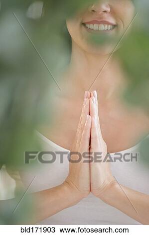 Mixed race woman meditating with clasped hands View Large Photo Image Stock Image - Mixed race woman meditating with clasped hands. Fotosearch