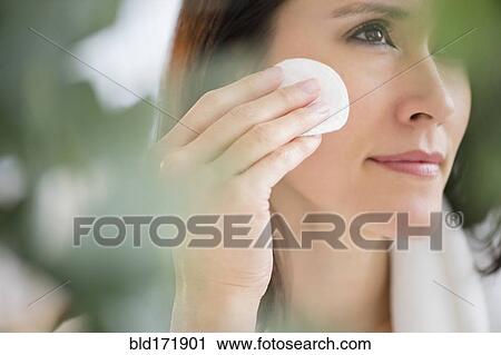 Mixed race woman patting makeup on face View Large Photo Image Stock Image - Mixed race woman patting makeup on face. Fotosearch