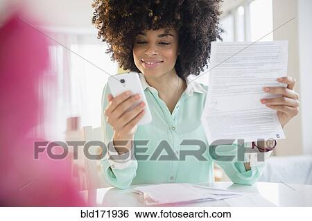 Mixed race woman paying bill with cell phone View Large Photo Image Stock Photograph - Mixed race woman paying bill with cell phone. Fotosearch