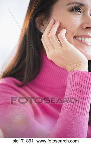 Stock Image - Mixed race woman resting chin in hand. Fotosearch