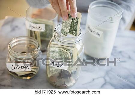 Mixed race woman saving money in jars View Large Photo Image Stock Photography - Mixed race woman saving money in jars. Fotosearch