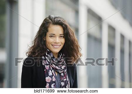 Stock Photo - Mixed race woman smiling in city. Fotosearch