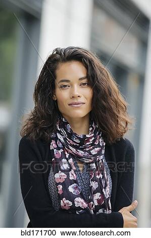 Mixed race woman standing in city View Large Photo Image Stock Image - Mixed race woman standing in city. Fotosearch