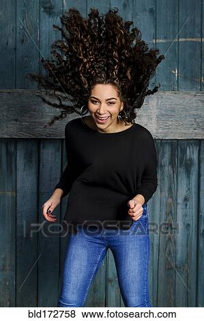 Stock Photo - Mixed race woman tossing her hair. Fotosearch