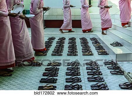 Stock Image - Monks leaving sandals near staircase. Fotosearch