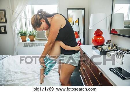 Mother and son hugging on bed View Large Photo Image Stock Photo - Mother and son hugging on bed. Fotosearch