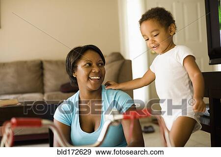 Stock Photo - Mother and son playing in living room. Fotosearch