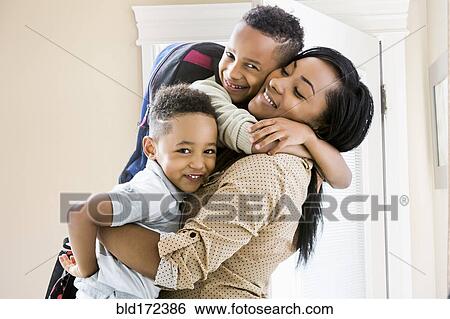 Mother and sons hugging at door View Large Photo Image Stock Photograph - Mother and sons hugging at door. Fotosearch