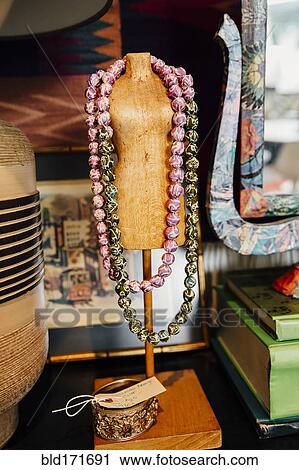Stock Image - Necklaces draped over mannequin stand. Fotosearch