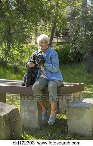 Older Caucasian woman hugging dog in park View Large Photo Image Stock Image - Older Caucasian woman hugging dog in park. Fotosearch