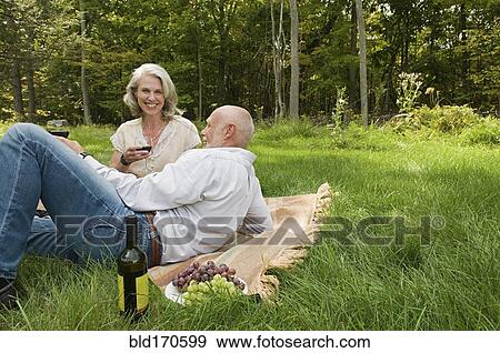Stock Photo - Older couple relaxing at picnic in park. Fotosearch