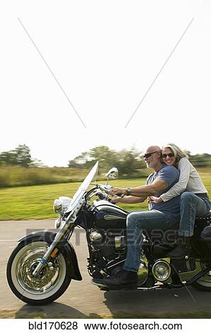 Older couple riding motorcycle on rural road View Large Photo Image Stock Photo - Older couple riding motorcycle on rural road. Fotosearch