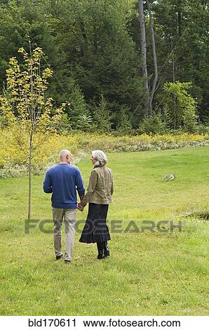 Older couple walking in park View Large Photo Image Stock Image - Older couple walking in park. Fotosearch