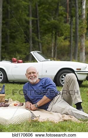 Older man laying on picnic blanket in park View Large Photo Image Stock Photograph - Older man laying on picnic blanket in park. Fotosearch