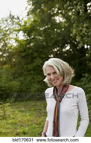 Older woman smiling in park View Large Photo Image Stock Image - Older woman smiling in park. Fotosearch