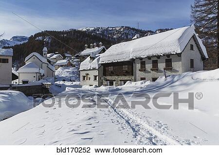 Stock Image - Path through snow to rural mountain village. Fotosearch