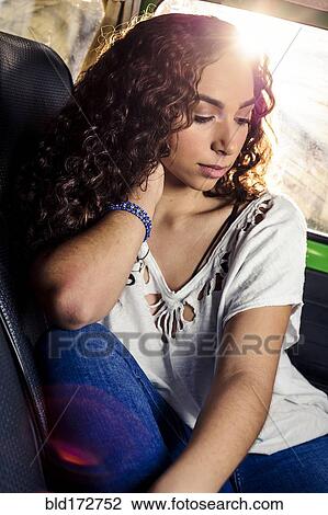 Stock Image - Pensive mixed race woman sitting in car. Fotosearch