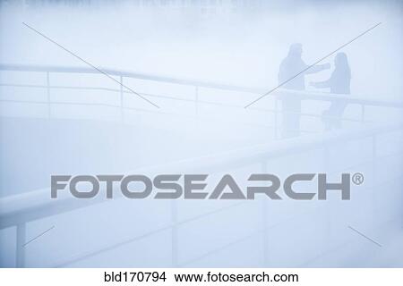 People standing on walkway in mist View Large Photo Image Picture - People standing on walkway in mist. Fotosearch