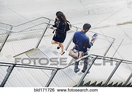 Stock Photograph - People using cell phones on city steps. Fotosearch